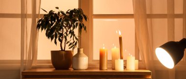 Geceleri oturma odasındaki çekmecelerin üzerine vazo ve bitki koyarak mum yakmak.