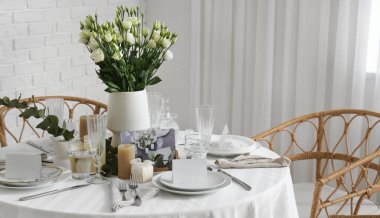 Oda da düğün kutlaması için çiçek ve mumlarla dolu güzel bir masa.