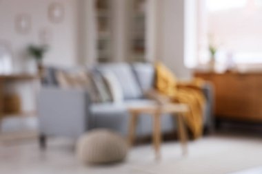 Gri kanepeli, raf üniteli, tuvalet ve sehpalı, bulanık manzaralı şık bir oturma odası.