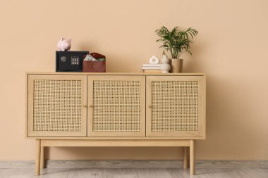 Domuz kumbaralı modern kasa, cüzdanda para ve bej duvarda klozet dekoru.