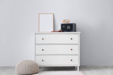 Kumbaralı modern kasa, cüzdanda para ve beyaz duvarın yanındaki tuvalette boya.