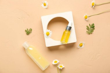 Kozmetik ürünleri şişeleri, alçı standı ve bej arka planda papatya çiçekleri.