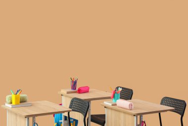 Bej arkaplan üzerine kalem, kitap ve kırtasiye içeren modern okul sıraları