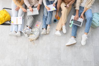 Üniversitenin zemininde okuyan bir grup öğrenci.