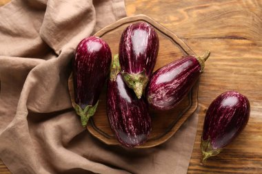 Tahta kesme tahtası ahşap arka planda taze olgun patlıcanlarla