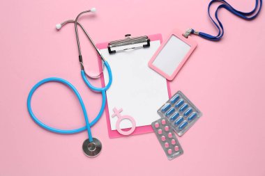 Rozetli pano, kadın sembolü, steteskop ve pembe arka planda haplar.