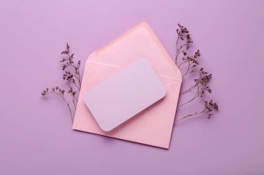 Zarflı kompozisyon, kurumuş çiçekler ve pembe arka planda boş bir kart, yakın plan.