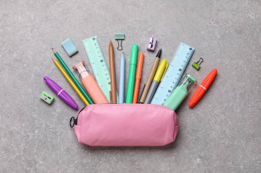 Gri grunge arka planında farklı okul kırtasiyesine sahip kalem kutusu