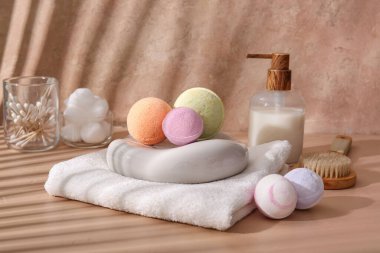 Havlu, taş ve bej arka planda farklı banyo bombaları ile kompozisyon, yakın plan