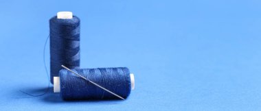 Mavi arkaplanda metin için boşluk olan iplikler ve iğne izleri