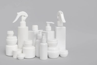 Gri arka planda kavanoz ve kozmetik ürünleri içeren kompozisyon