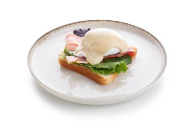 Beyaz arka planda lezzetli yumurtalı Benedict tabağı