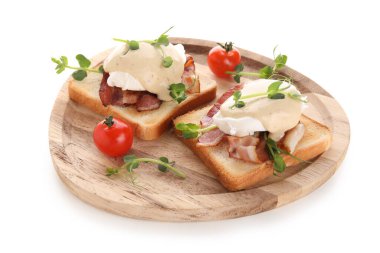 Lezzetli yumurta tabağı pastırmalı Benedict ve beyaz arka planda mikro yeşil.