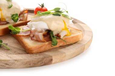 Lezzetli yumurta tabağı pastırmalı Benedict ve beyaz arka planda mikro yeşil.