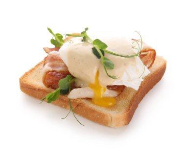 Pastırmalı Benedict yumurtası ve beyaz arka planda mikro yeşil.