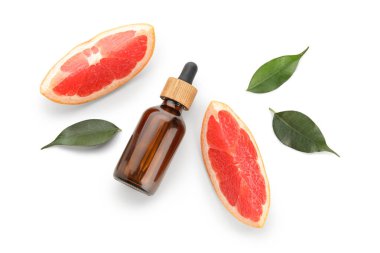 Beyaz arka planda izole edilmiş greyfurt yağı şişesiyle bileşimi, yakın plan