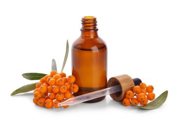 Beyaz arka planda izole edilmiş bir şişe Rowan esaslı yağ ve malzeme.