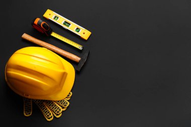 Siyah arkaplan, üst görünüm üzerine sert şapka ve inşaat araçları