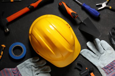 Siyah grunge arka plan, üst görünüm sert şapka, eldivenler ve inşaat araçları