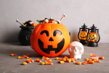 Cadılar Bayramı için arkaplanda lezzetli şeker ve süslemeler olan sepet.