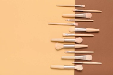 Renk arkaplanındaki farklı makyaj fırçaları