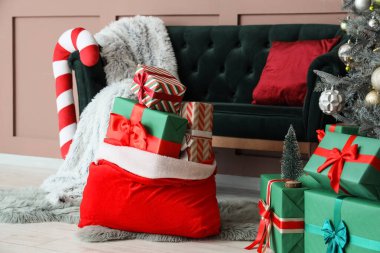 Noel hediyeli Noel çantası oturma odasındaki kanepenin yanında.