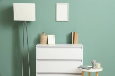 Beyaz klozet, lamba ve masa olan odanın içi.