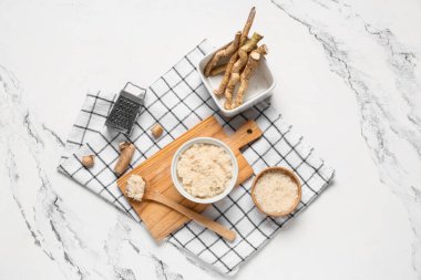 Tahta kesme tahtası, peçete ve mermer zemin üzerinde yabanturpu sosu.