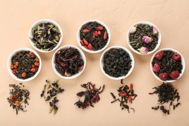 Bej arka planda farklı meyve çayları olan kaseler