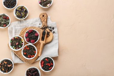 Bej arka planda farklı meyve çayları olan kaseler