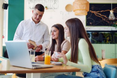 Mutlu garson bayan müşteriyle konuşuyor.