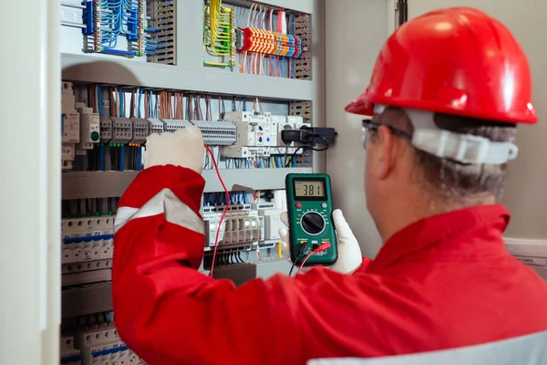 電気および電気メンテナンスサービス エンジニア手は電流電圧をチェックAc電圧計を保持 ストックフォト