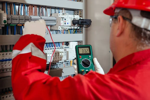 電気および電気メンテナンスサービス エンジニア手は電流電圧をチェックAc電圧計を保持 ストックフォト