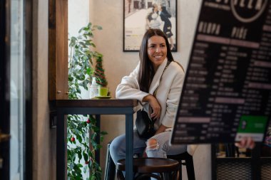 Güzel bir kadın restoranda menüden sipariş veriyor.