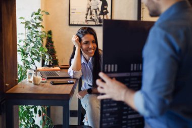 Güzel bir kadın restoranda menüden sipariş veriyor.