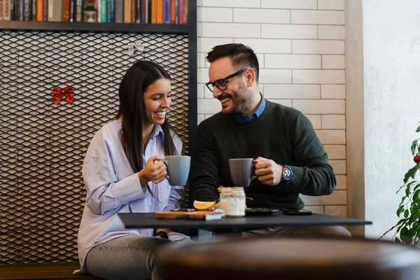 Couple having coffee at a coffee shop. Man and woman meeting at cafe.