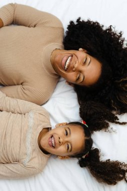 Afro Anne ve Kızı Kucaklaşarak Yatakta Yatıyor. Seçici Odaklanma, Üst Görünüm