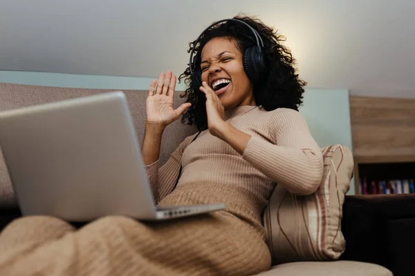 Mulher Africana Sorridente Fones Ouvido Usando Computador Portátil Enquanto Sentado — Fotografia de Stock