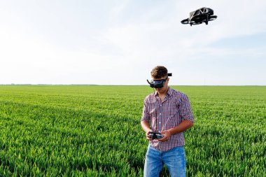 Buğday tarlasında uzaktan kumandalı ve sanal gerçeklik kulaklıklı tarım aracı pilotu.