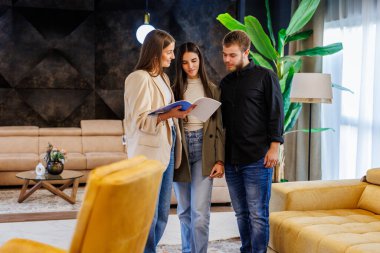 Emlakçı, yeni bir ev almak isteyen bir çifte belgeleri sunuyor.