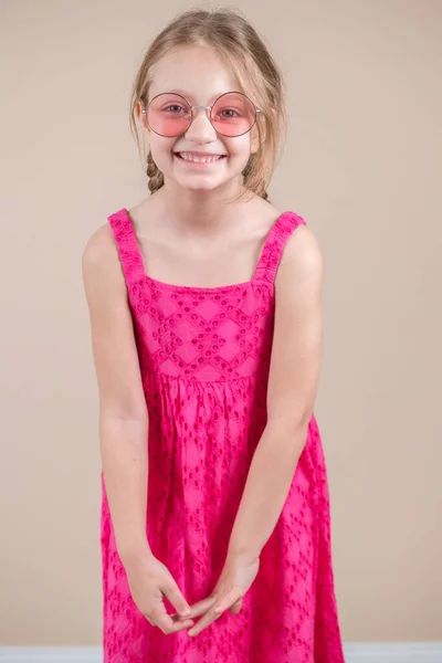 Blondes Mädchen Mit Rosa Kleid Und Sonnenbrille Lächelt — Stockfoto