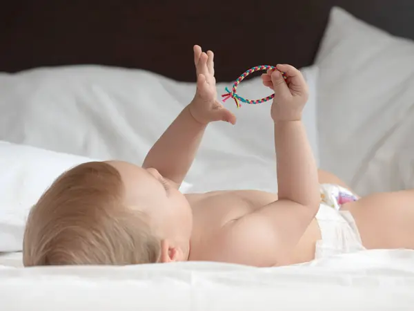 Pequeno Bebê Está Deitado Cama Brincando Com Brinquedo Fotos De Bancos De Imagens