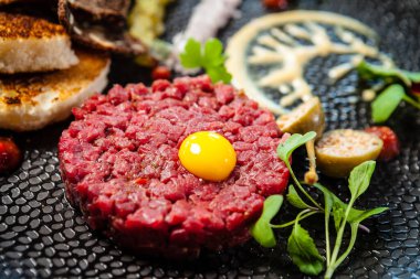 Black Angus 'tan sığır etli tartar. Soğan, bıldırcın yumurtası, domates sosu, hardal mayonezi. Lezzetli sağlıklı İtalyan geleneksel yemekleri modern gurme mutfağında öğle yemeği için servis edilir..