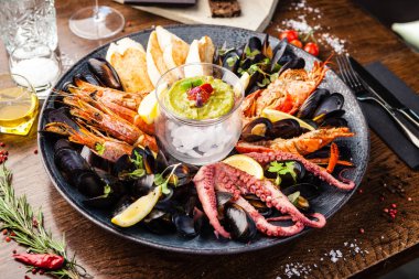 2-4 kişi için deniz ürünleri tabağı. Istakoz, ahtapot, mavi midye, Arjantin kral karidesi, ton balığı. Modern gurme yemek restoranında öğle yemeği olarak sunulan lezzetli, sağlıklı geleneksel yemekler..