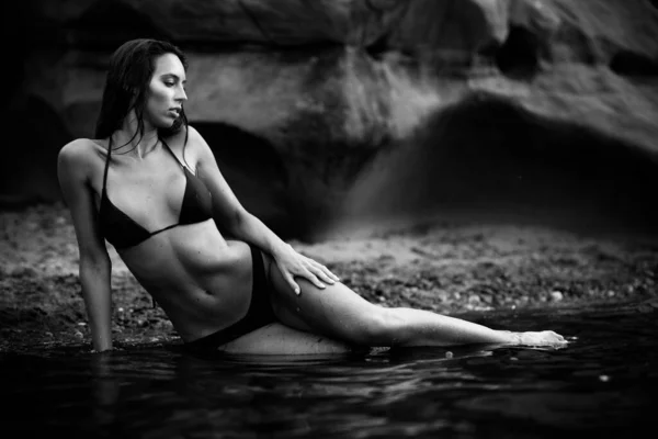 夏のレクリエーションの概念 黒の水着ビキニを身に着けているフィット訓練されたスリムボディを持つ美しい若いセクシーな女性はビーチにあります ファッション女性モデルは海によってポーズ 白黒モノクローム — ストック写真