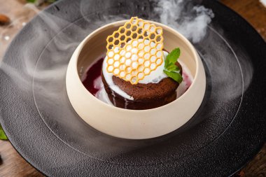 Çikolatalı şeker. Koyu çikolata, ahududu sosu, vanilyalı dondurma tatlısı. Modern gurme yemek restoranında öğle yemeği olarak sunulan lezzetli, sağlıklı geleneksel yemekler..