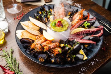 2-4 kişi için deniz ürünleri tabağı. Istakoz, ahtapot, mavi midye, Arjantin kral karidesi, ton balığı. Modern gurme yemek restoranında öğle yemeği olarak sunulan lezzetli, sağlıklı geleneksel yemekler..