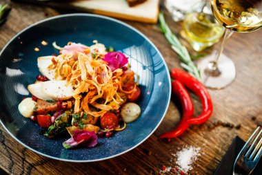 Tavuklu sıcak salata. Badem patatesi, mini romaine marulu, havuç, vişneli domates, pesto, siyah kök cipsi, karamelli ceviz, pancar balzamisi. Modern restoranda yemek servisi var..