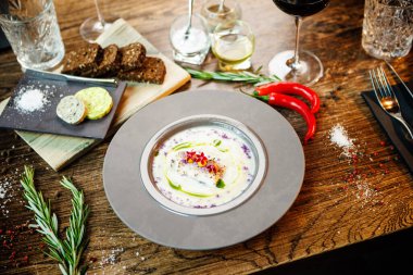 Kudüs enginar-badem kremalı çorba ve deniz tarağı rulosu. Pırasa, badem sütü, sarımsak. Lezzetli, sağlıklı, geleneksel Yahudi yemekleri modern gurme restoranındaki bir masada öğle yemeği için servis ediliyor..