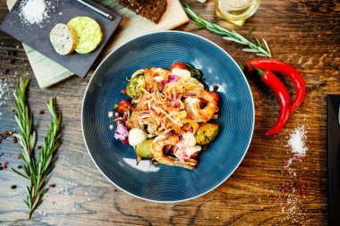 Arjantin kral karidesli sıcak salata. Badem patatesi, mini romaine marulu, havuç, vişneli domates, pesto, siyah kök cipsi, karamelli ceviz, pancar balzamisi. Modern restoranda yemek servisi..